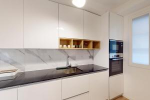 尼斯Loft Victor Hugo 73 Fshh的厨房配有白色橱柜、水槽和窗户。