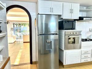 埃斯特角城Beautiful Chalet Punta del Este的厨房配有不锈钢冰箱和白色橱柜
