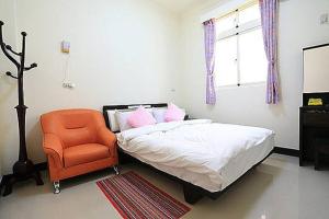 金湖镇成功民宿 KM Bed and Breakfast的一间卧室配有一张床和一张橙色椅子