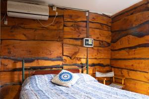 坦迪尔Cabañas El Viejo Sauce的卧室配有木墙内的一张床