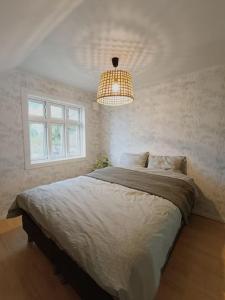 于尔斯泰因维克Charming house in Ulsteinvik with free parking的一间卧室配有一张大床和一个吊灯。