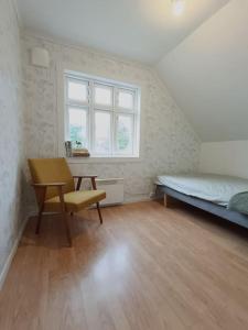 于尔斯泰因维克Charming house in Ulsteinvik with free parking的卧室配有床、椅子和窗户。