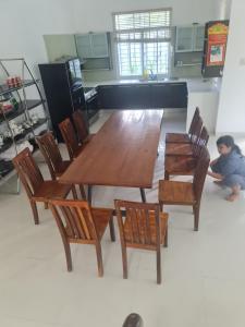 芽庄Nha Trang Riverside Villa的一张木桌和椅子,一个儿童坐在地板上