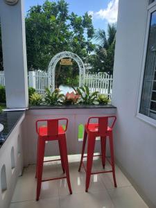 芽庄Nha Trang Riverside Villa的两把红色椅子坐在带窗户的阳台上