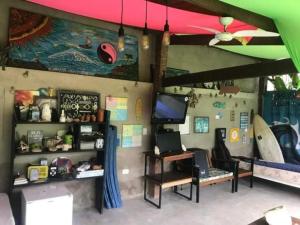 博西坎加Farah Suítes e Passeio de barco的一间设有一张桌子的房间和墙上的冲浪板