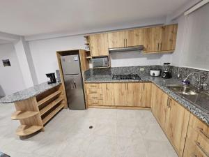 里奥班巴New Dawn Rio的厨房配有木制橱柜和不锈钢冰箱。