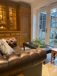 普拉姆斯特德Beautiful Traditional English 4 bedroom home in Greenwich的客厅配有真皮沙发和桌子