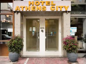 雅典雅典城市酒店的入口处,前面有两株盆栽植物