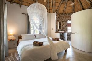 MamonoMobola Lodge的一间卧室配有一张带蚊帐的床