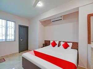 兰奇OYO Flagship Sona Residency的卧室配有带红色枕头的白色床