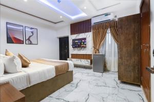 伊凯贾God's Touch Apartments Remi Fani Kayode GRA. Ikeja的一间卧室配有一张特大号床和一台电视