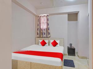 兰奇OYO Flagship Sona Residency的一间卧室配有一张带红色枕头的床和一扇窗户