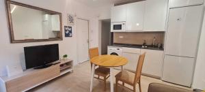 马德里Precioso apartamento recién reformado的一个带桌子和电视的小厨房