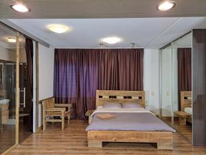 里加Champêtre Park View Apartments的一间卧室配有一张大床和紫色窗帘