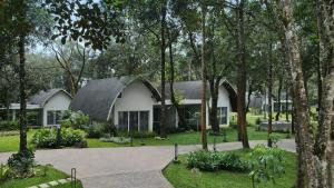 马迪凯里Coorg Marriott Resort & Spa的公园中树木繁茂的房屋