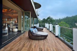 马迪凯里Coorg Marriott Resort & Spa的房屋内一个带沙发和椅子的甲板