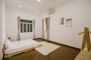 芽庄Nha Trang Riverside Villa的白色的客房设有床和窗户。
