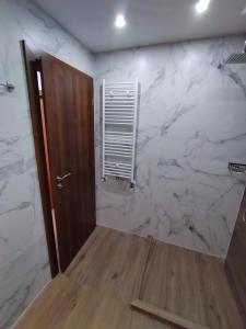 PernikПри митака的一间设有白色大理石墙和门的浴室