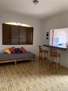 维索萨Quartos em casa no Clelia Bernardes的配有一张床和一张桌子及椅子的房间