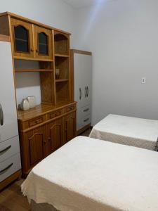 维索萨Quartos em casa no Clelia Bernardes的一间卧室设有两张床和木制橱柜