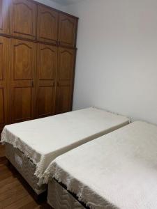 维索萨Quartos em casa no Clelia Bernardes的配有木柜的客房内的两张床
