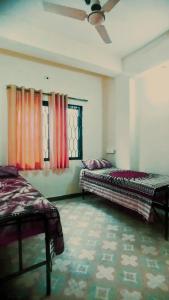 迈索尔Funky Buddha Hostel的一间卧室设有两张床和窗户。