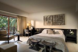 阿克拉拉巴迪海滩酒店的一间卧室配有一张床和一张书桌,另一间卧室配有一张桌子。