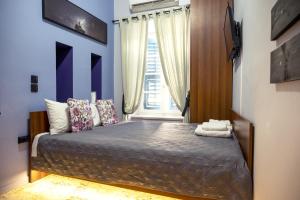 纳夫普利翁Deisisroom nafplio Afroditi的一间卧室配有一张蓝色墙壁的床和一扇窗户