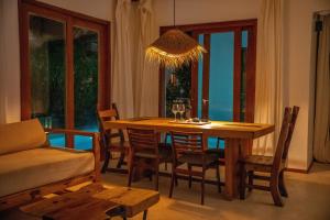平圭Natural Park Villa Resort的一间带木桌和椅子的用餐室