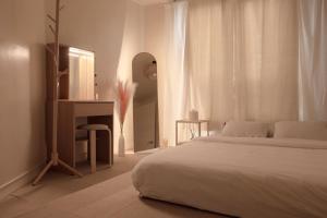 首尔Seoul Sensibility B&B House的白色卧室配有床和镜子