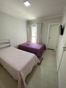 伊达贾伊Suíte Premium的一间卧室设有两张床和窗户。