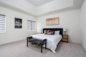 MidhurstCustom Build 5 Bedroom Villa (Ski Resort)的白色卧室配有床和椅子