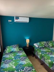 拉斯塔布拉斯Uverito Sand Dollar B&B的一间设有两张蓝色墙壁床的房间
