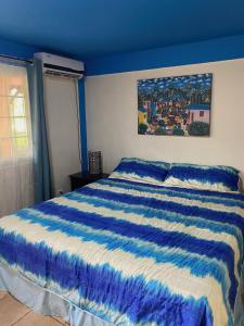 拉斯塔布拉斯Uverito Sand Dollar B&B的蓝色卧室,配有一张带蓝色和白色棉被的床
