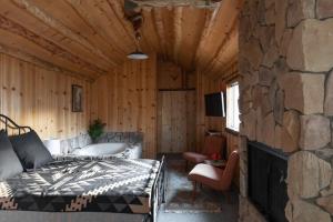 大熊湖2412 - Oak Knoll Studio with Jacuzzi #15 cabin的一间卧室设有一张床和石墙