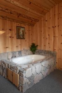 大熊湖2412 - Oak Knoll Studio with Jacuzzi #15 cabin的木墙客房内的大型石头浴缸