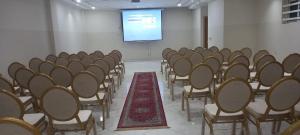 贝尼迈拉勒HOTEL PALACE AL SALAM , Beni Mellal的一个带椅子和投影屏幕的讲座室