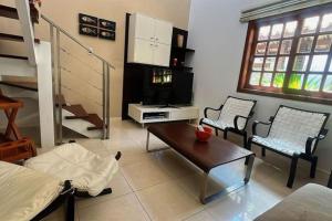 普拉亚多Apartamento duplex em Praia do Forte - 2 suítes的客厅配有两把椅子和一张桌子