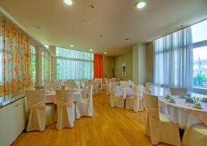 雅典公园酒店 的宴会厅配有白色的桌椅
