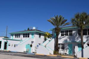 圣徒皮特海滩Renovate Large Studio 21-Directly Across Beach的一座白色的建筑,前面有棕榈树