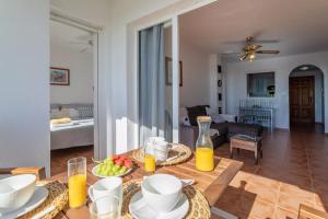穆特克萨梅尔Golf Bonalba Alicante "Servall Host"的客厅配有餐桌,提供食物和橙汁