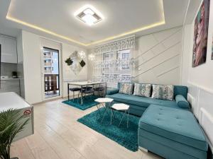 兹拉蒂博尔Apartmani SLEEP&JOY的客厅配有蓝色的沙发和桌子