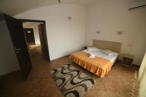 克卢日-纳波卡泽波尔旅馆的一间卧室配有一张带橙色棉被的床