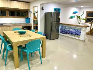 普罗维登西亚La Casita Azul Boutique Villa的厨房配有桌椅和冰箱。