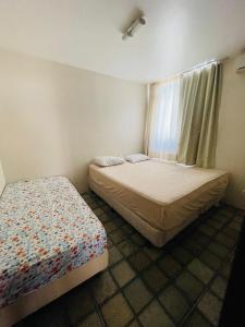 拉巴拉德纳圣米格尔Condomínio Rochas do Mar的一间卧室设有两张床和窗户。