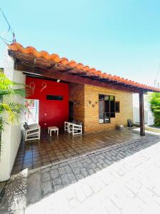 拉巴拉德纳圣米格尔Condomínio Rochas do Mar的一座带红色门和庭院的房子