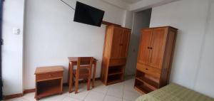 奥克萨潘帕Hospedaje Olguita的一间卧室配有木制家具、一张床和一张书桌