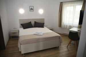 克卢日-纳波卡泽波尔旅馆的卧室配有一张白色大床和一张书桌