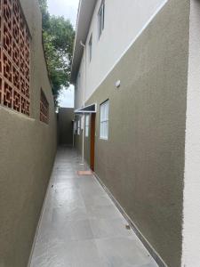 大普拉亚Casa novinha - Praia Grande - Mirim - 3 quadras da Praia Wi-Fi的建筑物旁边的空走廊