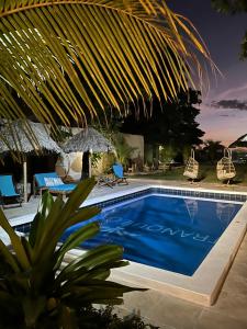 拉斯彭尼塔斯Hotel Tranquilo的一个带椅子和遮阳伞的游泳池